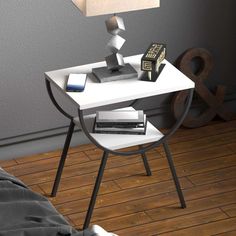 a white table with a lamp on top of it next to a book and cell phone