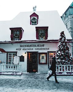 a person walking in front of a building covered in snow