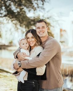 a man and woman holding a baby in their arms