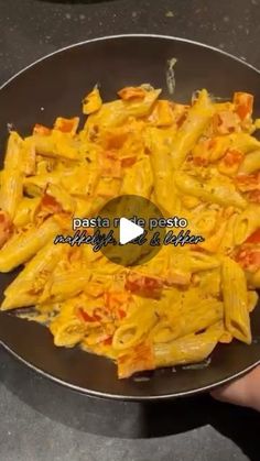 someone is cooking pasta in a pan on the stove top with cheese and tomato sauce