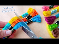 someone is using scissors to cut the thread off of some yarns and crochet hooks