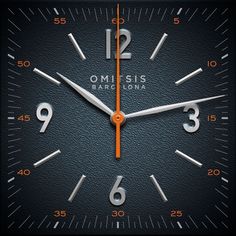 a close up of a clock on a black surface with orange hands and numbers in the middle