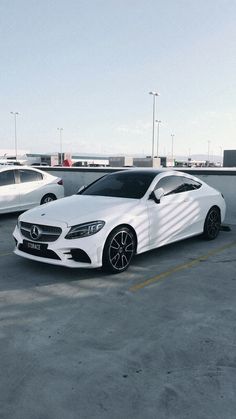 two white cars parked next to each other in a parking lot