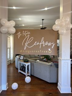 balloons are floating in the air above a living room with couches and tables on wooden floors