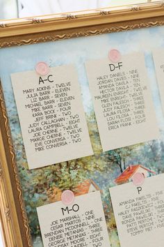 the wedding seating chart is displayed in an ornate gold frame with pink flowers on it