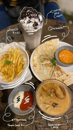 a table topped with plates of food next to a cup filled with sauces and condiments