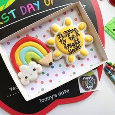 a birthday cake in the shape of a sun and rainbow on top of a box