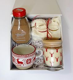 an open box containing two mugs, cookies and other items to make christmas gifts