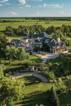 an aerial view of a large home in the middle of a lush green field with lots of trees