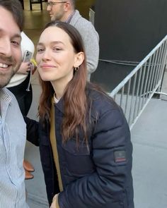 a man and woman standing next to each other in front of a building with stairs