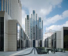 an empty walkway between two large buildings in the middle of a city with tall skyscrapers