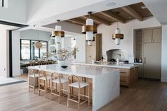 a large kitchen with an island in the middle and lots of stools around it