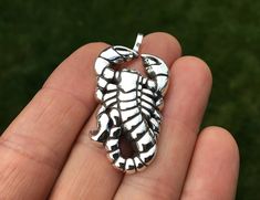 "Hand carved, cast scorpion scorpio pendant / necklace in sterling silver by artist and designer Paxton Mobley (Please Note: This is a larger sized pendant (one of the listing images shows the pendant's size). We also offer a smaller charm size of this design). This original handcrafted scorpion scorpio pendant is sold by itself or with a genuine black leather 3mm cord with sterling silver end caps and lobster clasp. The pendant's bail opening that the cord or chain fits through is approx. 4.7mm Carved Silver Necklace For Gift, Silver Carved Necklace For Gift, Silver Carved Round Pendant Necklace, Sterling Silver Carved Necklace For Gift, Carved Sterling Silver Necklace Gift, Carved Sterling Silver Necklace For Gift, Carved White Gold Necklaces As Gift, Carved White Gold Pendant Jewelry, Sterling Silver Carved Pendant Jewelry