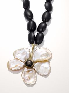 Pearl & Stone Necklace - Crafted in 10k yellow gold, this exquisite pendant features five pearl petals encircling a black star sapphire center. The pearl flower pendant is suspended from a strand of double-knotted black star diopside oval beads, each displaying its own star that sparkles under bright light. The hand-fabricated toggle clasp mirrors the shape of the flower pendant, with each end set with miniature black star sapphires. Each limited edition black and white flower necklace is un Elegant Black Jewelry With Flower Charm, Elegant Oval Jewelry With Flower Charm, Black Flower Charm Pendant Jewelry, Black Jewelry With Flower Charm Pendant, Elegant Black Necklace With Flower Charm, Elegant Black Pendant Pearl Necklace, Formal Black Jewelry With Pearl Charm, Black Pearl Jewelry, Black Star Sapphire