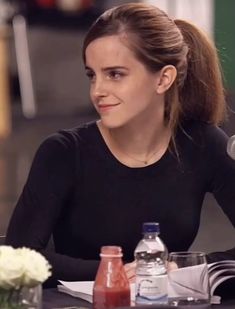 a woman sitting at a table in front of a microphone