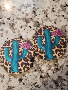 pair of cactus and leopard print earrings on granite counter top