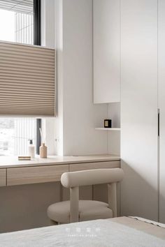 a bedroom with a bed, desk and chair in front of a window that has blinds on the windowsill