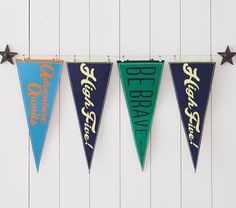 three pennants hanging from the side of a white wall