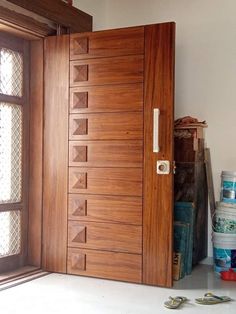 an open wooden door in front of a window with tools on the floor next to it