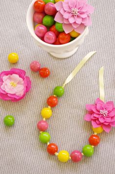 a bowl of candies, candy and flowers on a table with the word love spelled out