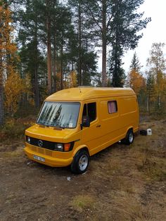 a yellow van parked in the middle of a forest