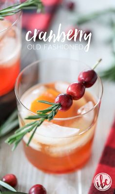 cranberry old fashioned cocktail is garnished with rosemary and fresh cherries