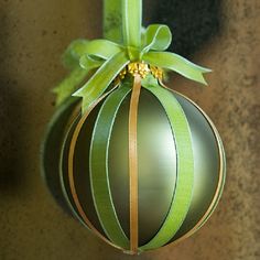 an ornament hanging from a green ribbon on a doorknob with a bow