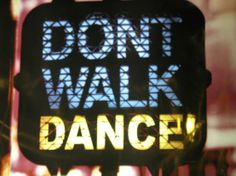 there is a sign that says don't walk and the words dance on it