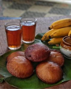 bananas and other foods on a table with some drinks in front of the food items