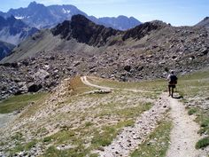 a man hiking up a trail in the mountains