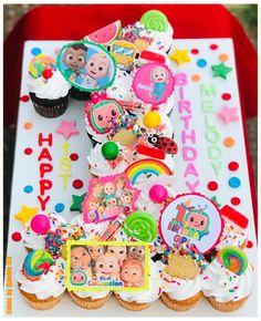 a birthday cake with cupcakes and decorations on it