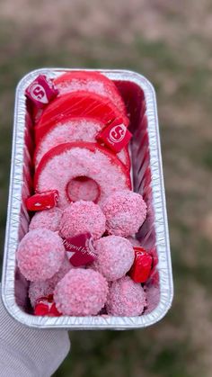 a person holding a container filled with candy