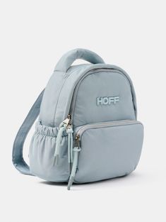 If you're looking for a backpack where you can carry your phone, your favorite book, your wallet, and a few more essentials, this is the one. Its design stands out in soft blue. It has a spacious front compartment, plus two additional ones on the sides for your water bottle. The padded interior takes care of everything you carry, and it includes a compartment for you to organize it as you like. The best part? Its security compartment on the back. The adjustable straps in a mindful tone feature the Jacquard logo. Perfect for a day of walking around your favorite city, pair it with Metro and elevate your street style.   Style: Mini Puffer Nylon Backpack.   Measurements: 26.5 cm x 28 cm x 12 cm. Handmade Fabric Bags, Blue Backpack, Fabric Bags, Favorite City, Mini Backpack, Kids Bags, Favorite Books, Bags Designer, The One