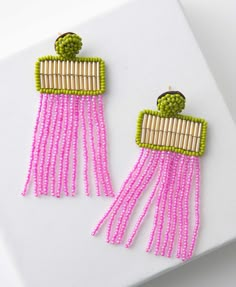 pink and green beaded earrings on white surface