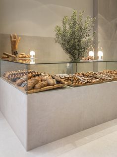 a display case filled with lots of different types of breads and pastries on top of glass shelves