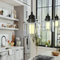 three lights hanging from the ceiling in a kitchen