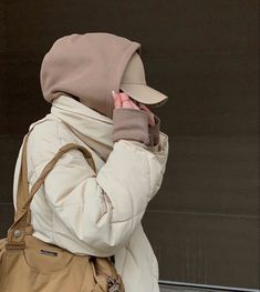 a woman wearing a white coat talking on her cell phone