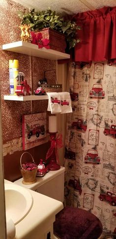 a bathroom decorated in red and white with lots of decor on the shelves above the toilet