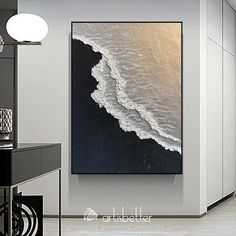 an abstract painting hangs on the wall in a modern living room with black and white decor