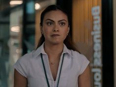 a woman standing in front of a building with a necklace on it's neck