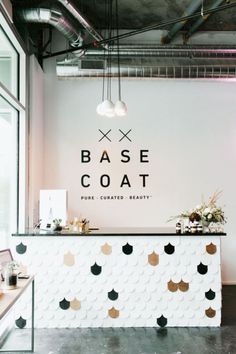 the front desk of base coat is decorated with gold and black circles on it's white wall