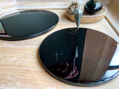 two circular mirrors sitting on top of a wooden table