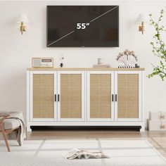 a tv mounted on the wall above a white cabinet with wicker doors and drawers