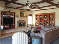 a living room filled with furniture and a flat screen tv mounted on a wall next to a fire place