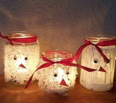 three mason jars with faces and lights in them