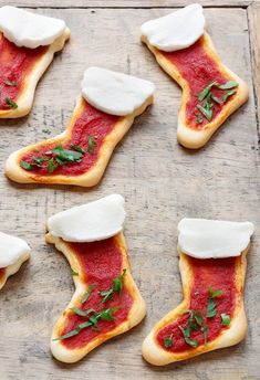 several pieces of bread with red sauce and cheese on them sitting on a wooden surface