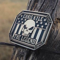 Legendary Attitude Belt Buckle A904CK Be legendary. Channel your inner warrior with this Chris Kyle buckle. Our Legendary Chris Kyle Attitude Belt Buckle is square in shape with clipped corners. It has a smooth trim with detailed filigree in the corners all in an antiqued silver tone. The rest of the buckle is hand-painted black with a silver-toned sniper skull in the center. The scope at his eye is red. The words "Chris Kyle. The Legend." frame the top and bottom of the sniper figure. The rest Luxury Leather Belt Buckles With Silver-tone Logo, Luxury Designer Belt Buckles With Silver-tone Logo Plaque, Buckles Western, Bling Jacket, Chris Kyle, Boys Cowboy Boots, Be Legendary, Girl Cowboy Boots, Twisted X Boots