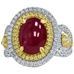 Introducing an extraordinary engagement ring that exudes luxury and elegance. At its heart is a breathtaking 4.91-carat purplish-red, unheated oval-shaped double cabochon cut ruby, GIA certified to ensure its authenticity and rare beauty. This stunning centerpiece is encircled by a double halo of vibrant yellow and sparkling colorless VS/SI clarity round cut diamonds, enhancing the ruby's unique allure. Complementing the central ruby are two pear-shaped diamonds, totaling 0.62 carats, each frame Luxury Women's Oval Cabochon Ruby Ring, Luxury Ruby And Diamond Oval Cabochon Ring, Luxury Yellow Gold Ruby Ring With Oval Cabochon, Luxury Ruby Ring Oval Cabochon Polished Finish, Luxury Yellow Gold Ruby Ring Oval Cabochon, Star Ruby Ring, Ruby Diamond Ring, Luxury Engagement Rings, Ruby Diamond Rings