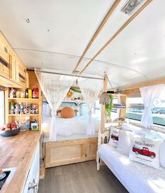 a bed sitting inside of a bedroom on top of a wooden floor next to a kitchen