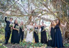 a group of women standing next to each other in front of a tree filled with flowers